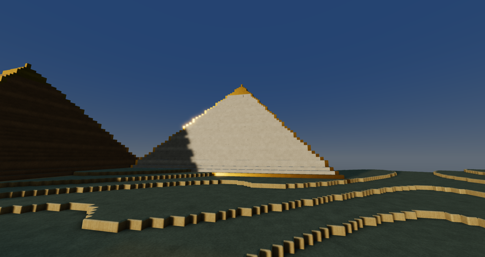 limestone pyramids with gold capstones over rippled dunes at dusk